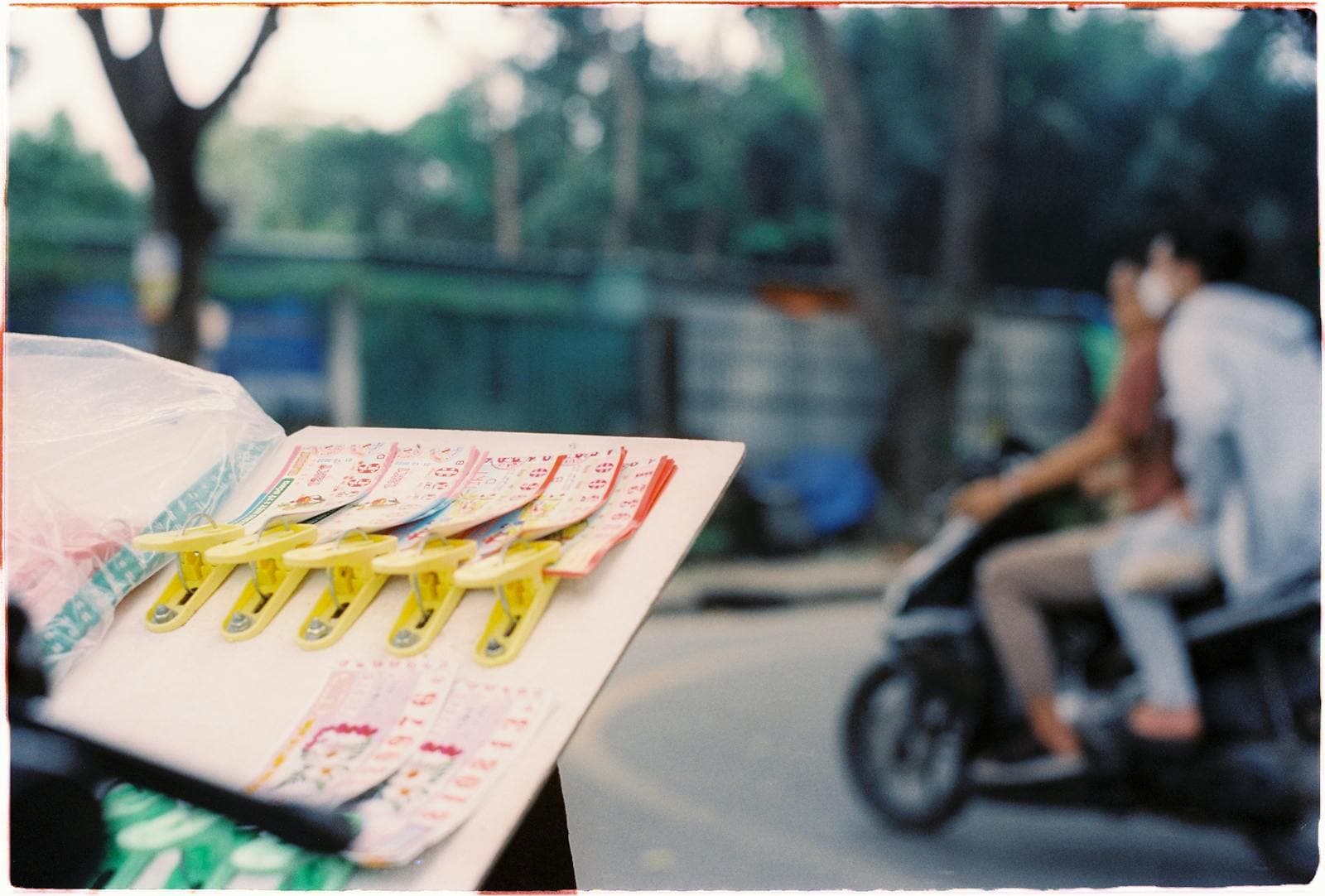 Multiple lottery scratch-off tickets displayed together on a clipboard-style board.