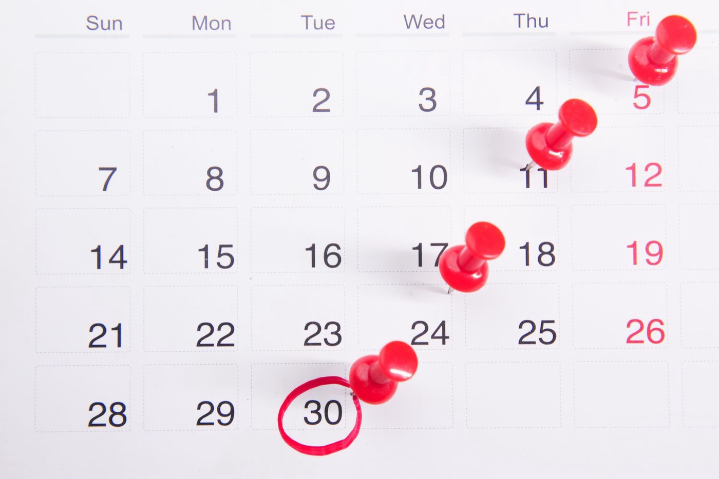 A calendar page with red pins marking a run of separate dates.