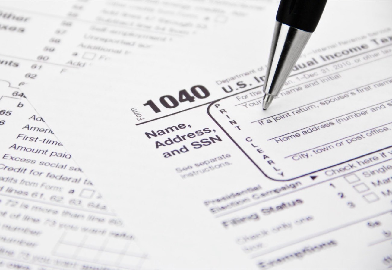 A pen resting on a partly completed IRS Form 1040 individual income tax return.